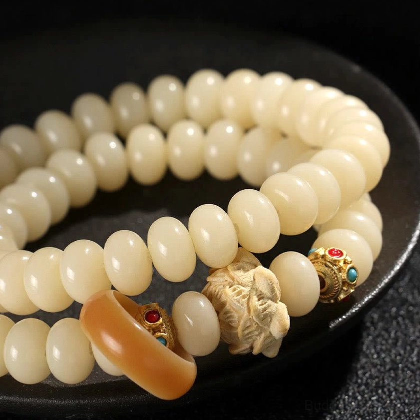 Close-up overhead view of bodhi seed bracelet beads and lotus charm - detailed texture of handcrafted Buddhist spiritual bracelet