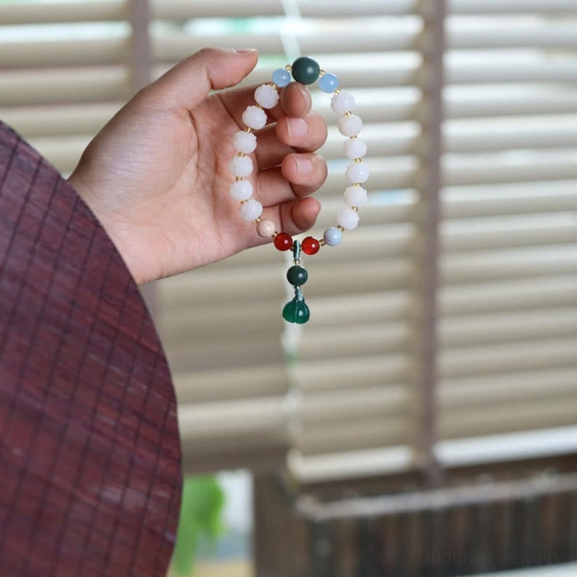 Handcrafted lotus bead bracelet with green lotus charm and mixed meditation beads close-up