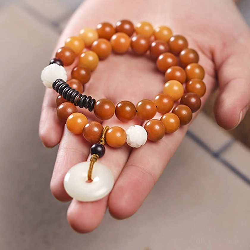 Bodhi seed bracelet material close-up showing 10mm cyan beads, jade peace buckle, small leaf red sandalwood, and coconut shell components