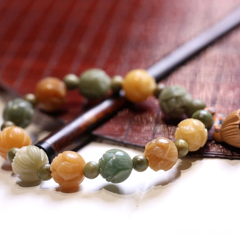 Close-up angled view of bodhi seed bracelet with mixed tone beads and lotus accents displayed on wooden table