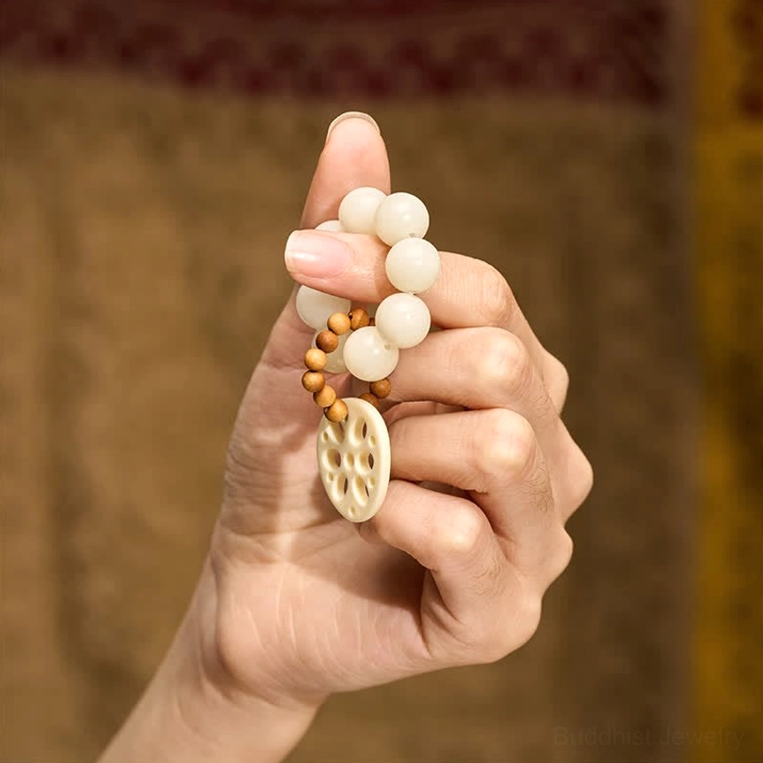 Bodhi seed meditation bracelet worn on fingers showing tactile grounding use with lotus pendant detail