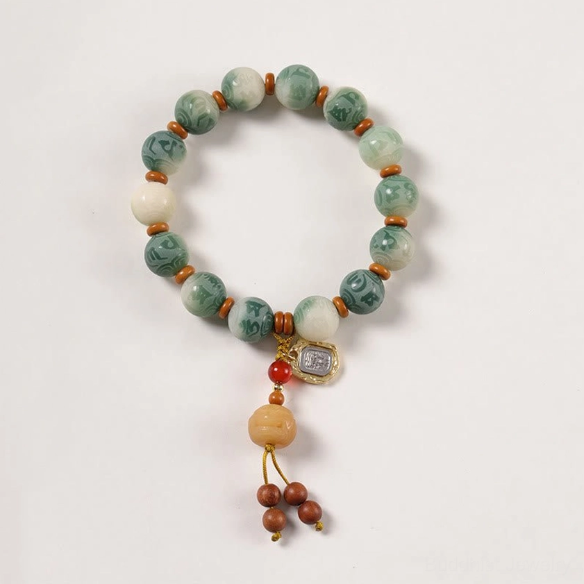 Overhead flat lay of Buddhist prayer bracelet with Bodhi beads and sacred symbol charm on white background