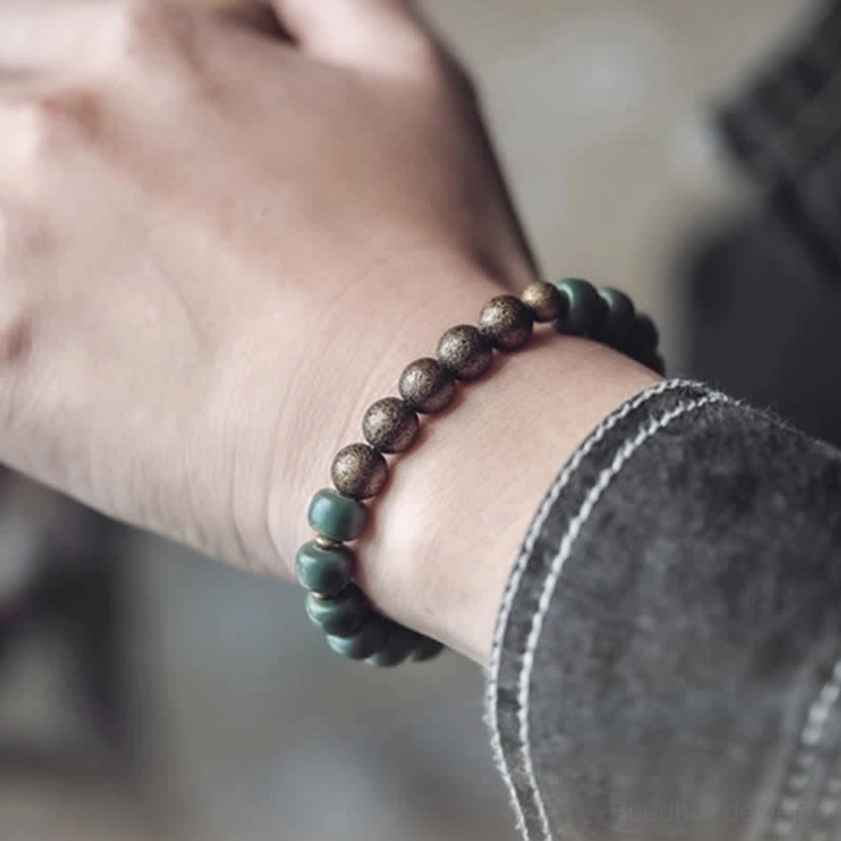 Cyan bodhi seed bracelet worn on wrist showing close-up fit and mixed round cyan and brown metal bead detail