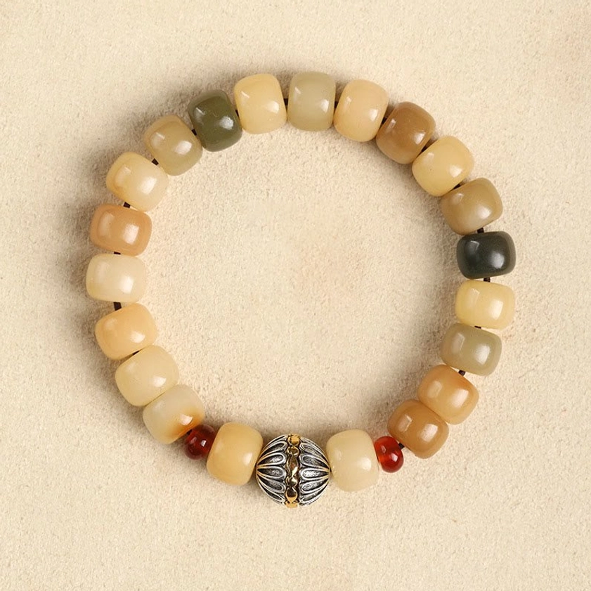 Bodhi seed bracelet with cosmos flower tassel accent, earthy barrel beads with decorative tassel charm, bohemian Buddhist jewelry flat lay
