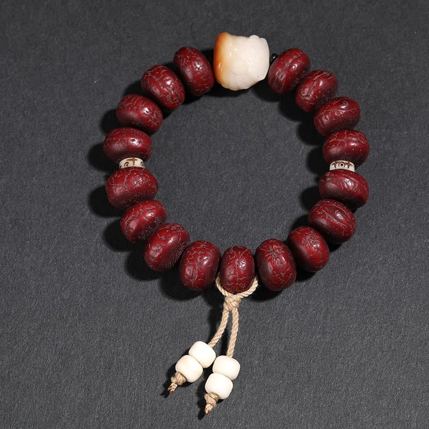 Minimalist bodhi seed bracelet with white carved animal-head bead and twine tassel - dancing lion motif