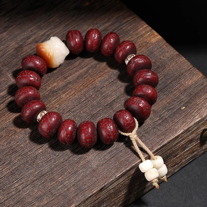 Sacred bodhi seed bracelet with white animal-head charm and traditional twine tassel - spiritual protection amulet