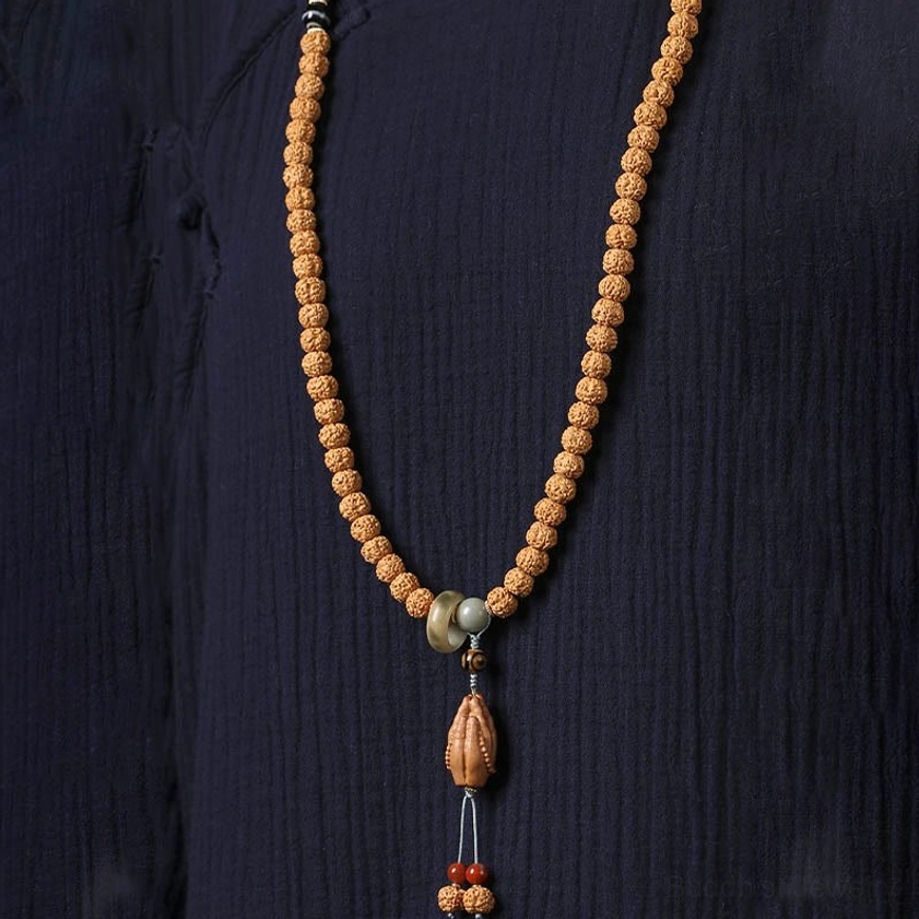 Buddhist bodhi seed bracelet with three-eye Dzi bead and spiritual Buddha hand charm close-up detail shot