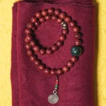 Bodhi seed cyan jade copper bracelet double-loop design flat lay top view on maroon cloth