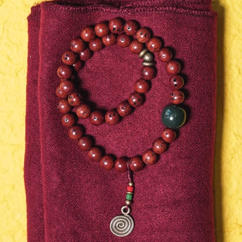Bodhi seed cyan jade copper bracelet double-loop design flat lay top view on maroon cloth