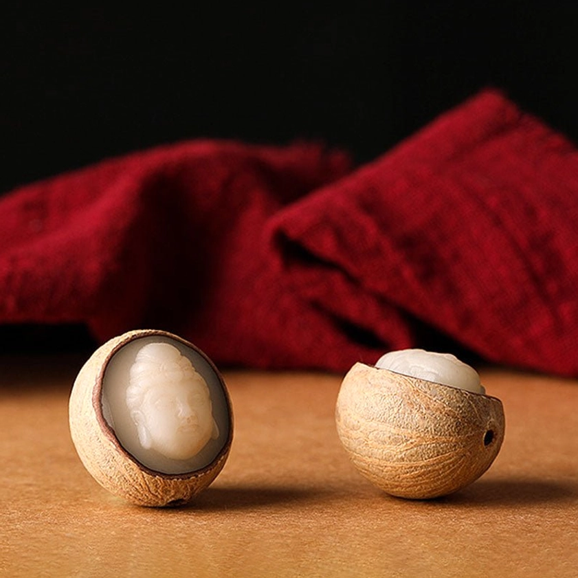 Flat lay of natural bodhi seed shell showing removable Buddha head insert and craftsmanship