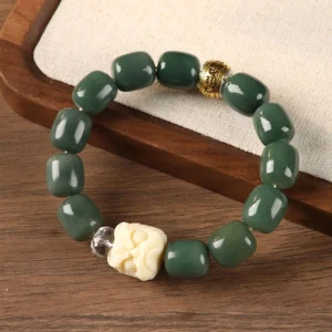 Bodhi seed om mani padme hum lion head bracelet with green barrel beads and carved ivory lion bead on wooden tray
