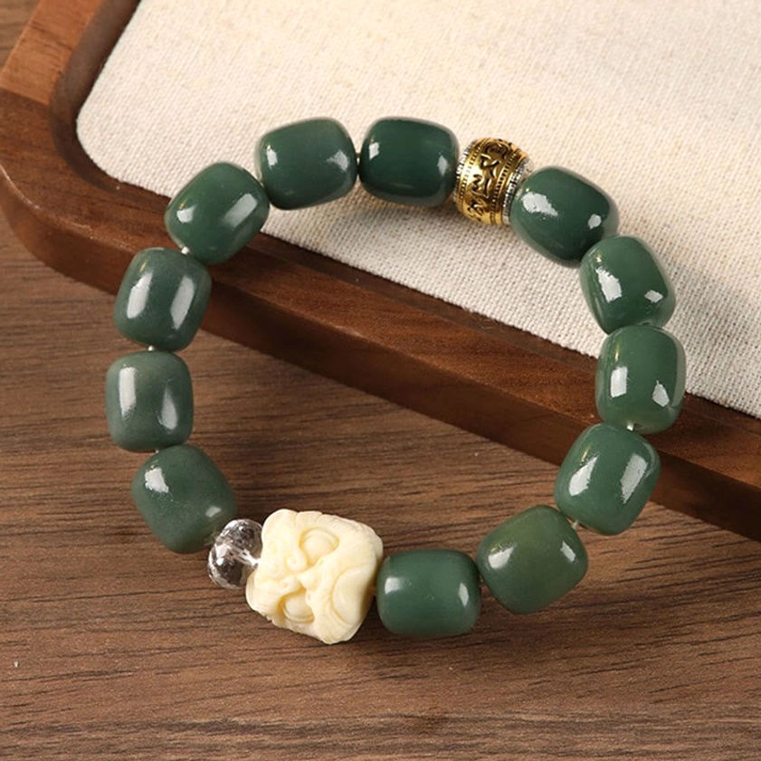 Bodhi seed om mani padme hum lion head bracelet with green barrel beads and carved ivory lion bead on wooden tray