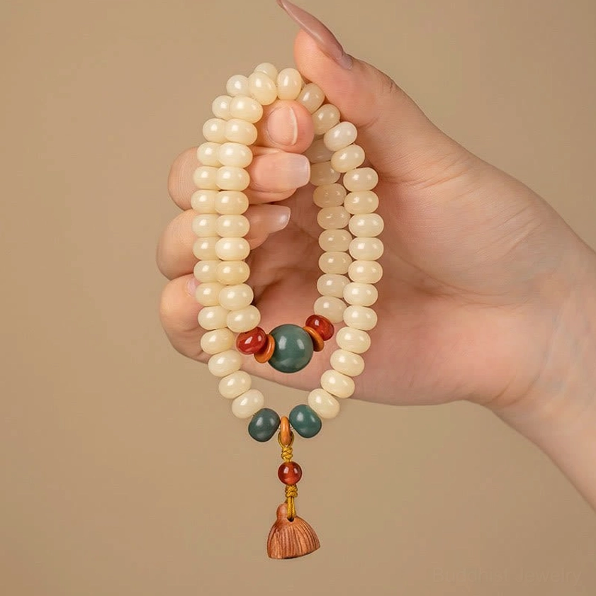 Double wrap Bodhi seed bracelet with wooden lotus pod charm hanging between two hands