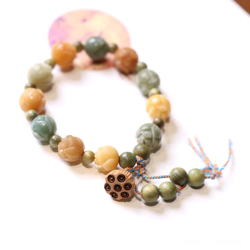 Bodhi seed lotus bracelet with multicolor carved beads and jujube lotus charm on white background, flat lay overhead view