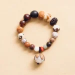 Bodhi seed lotus mala bracelet flat lay with lotus pendant charm on neutral background