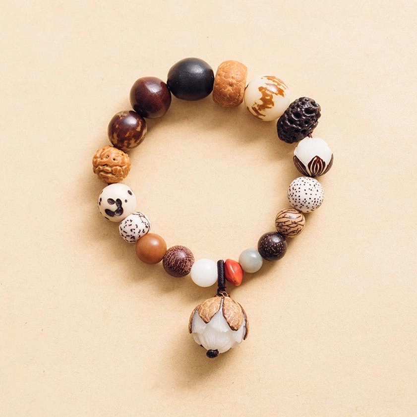Bodhi seed lotus mala bracelet flat lay with lotus pendant charm on neutral background