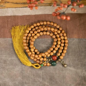 108 bodhi seed mala beads bracelet flat lay with yellow tassel and jade cinnabar accents