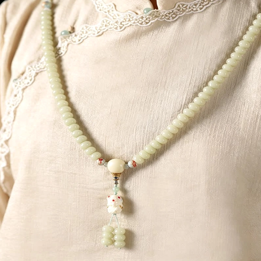White bodhi seed 108 mala beads with Tara pendant necklace detail shot showing bead texture and carving