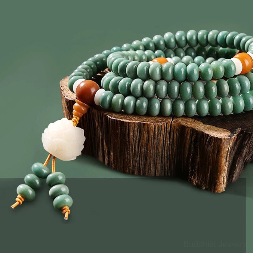 Stacked green bodhi seeds on wooden stump display with lotus pendant and decorative bead tassel
