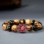Bodhi seed Om Mani Padme Hum bracelet with red cinnabar Bagua charm - flat lay overhead view on grey background
