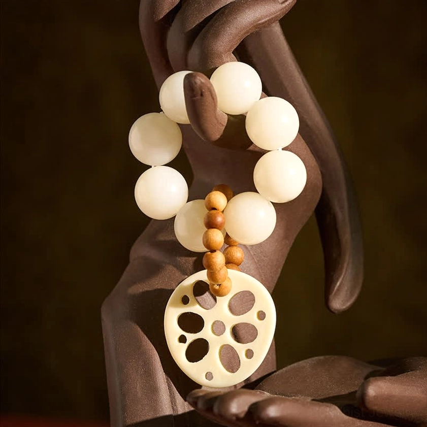 Bodhi seed meditation bracelet close-up side view showing lotus root pendant detail with Buddha hand prop
