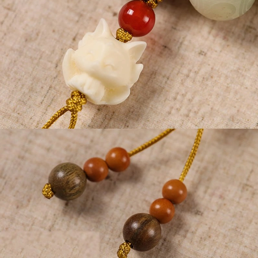 Handmade Bodhi seed bracelet with Om Mani Padme Hum mantra and protective charm on wooden surface