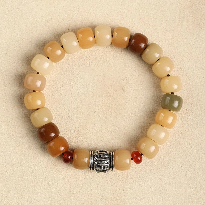 Bodhi seed bracelet with Om Mani Padme Hum sacred mantra engraved focal bead, earthy barrel beads with red accent spacers, overhead flat lay view