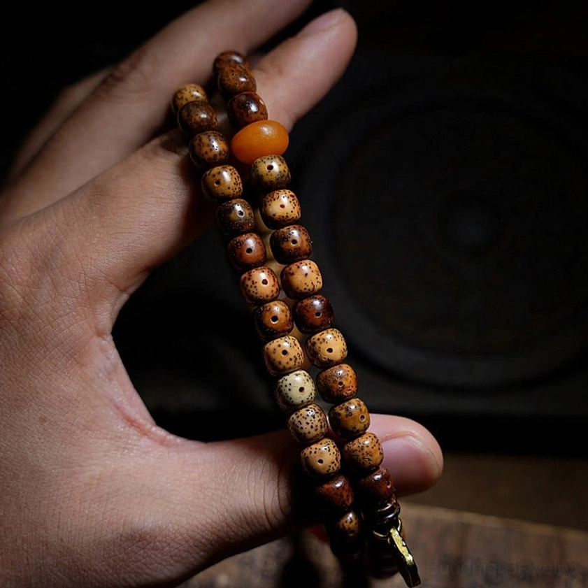 Handheld Buddhist prayer bead strand with bodhi seeds orange agate beads and metal clasp detailed view