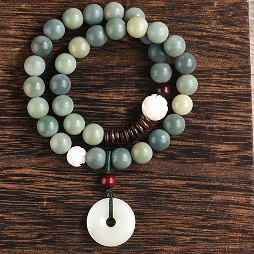 Cyan bodhi seed prayer bracelet with jade peace buckle charm showing red sandalwood spacer beads and natural material craftsmanship
