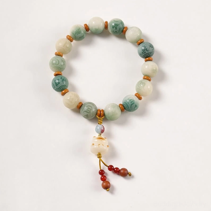 Bodhi beaded prayer bracelet with lotus-shaped pendant and red tassel on pure white background