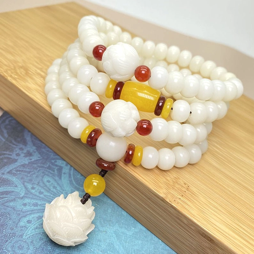 Buddhist prayer mala bracelet with natural bodhi seeds and red yellow spacer beads, three quarter angle display