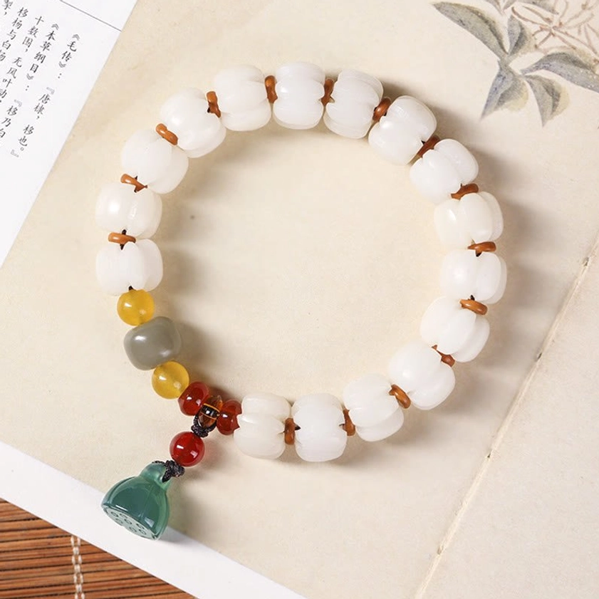 Bodhi seed red agate green aventurine lotus bracelet flat lay desktop view with spiritual accessories