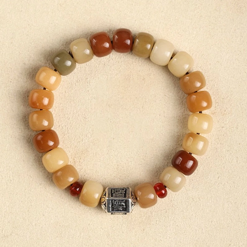 Bodhi seed beaded bracelet with smooth character bead design, earthy wooden beads with carved focal bead, flat lay presentation on neutral background