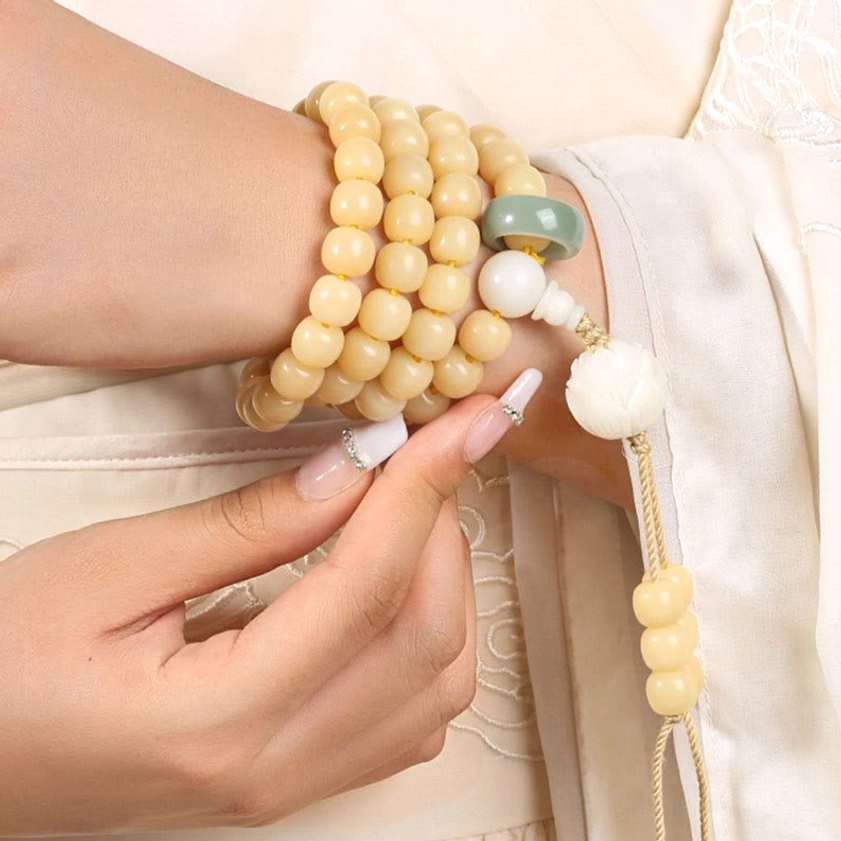 Stackable Bodhi Seed Bracelets front view being adjusted on wrist with jade and lotus details