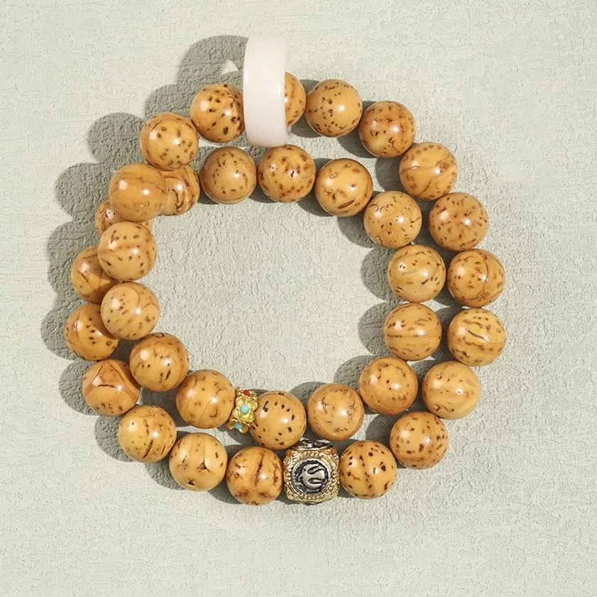 Light brown double wrap bodhi seed bracelet with matte textured beads, metal charm and white ring spacer