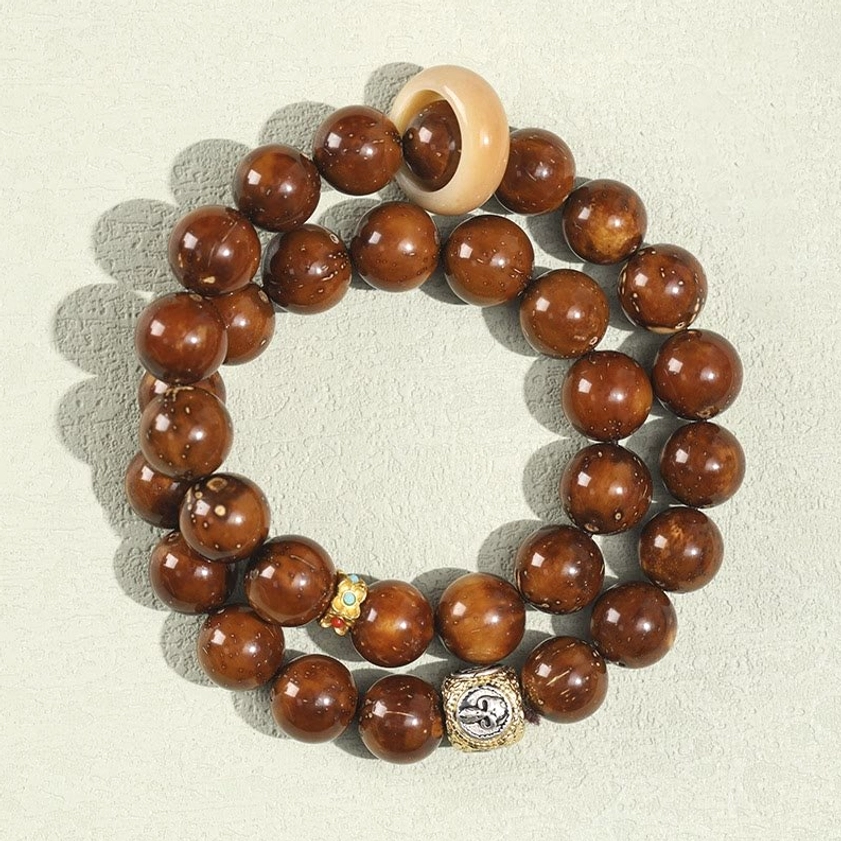 Double wrap bodhi seed wealth bracelet overhead view with brown smooth beads and light ring spacer detail