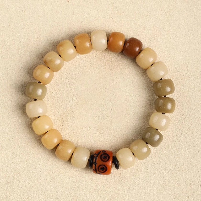 Bodhi seed and yak bone beaded bracelet with authentic Himalayan materials, earthy tones and carved focal bead, traditional Buddhist jewelry flat lay