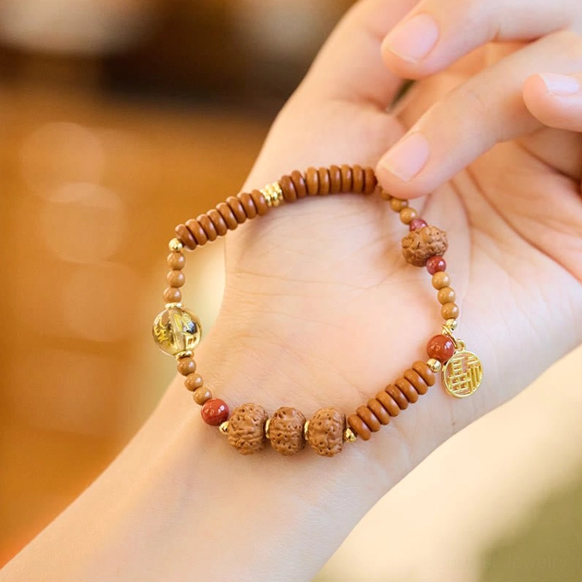 Bodhi seed smoky quartz bracelet with clear gold foil bead and gold Fu charm displayed in palm