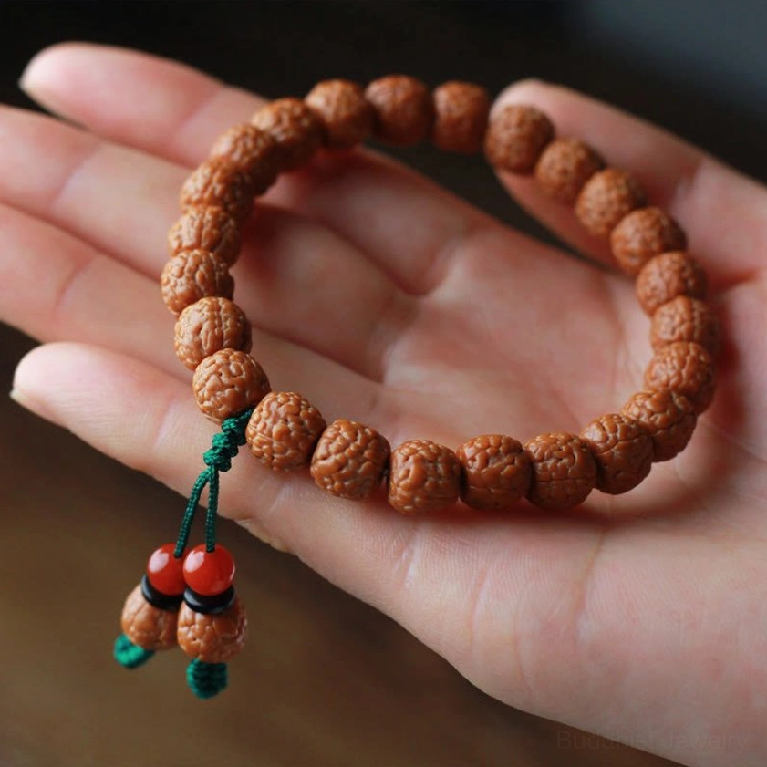 Sacred Bodhi seed wealth bracelet in palm close-up with green tassel and agate beads