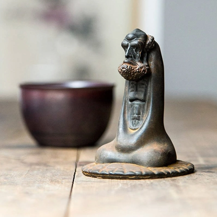 Bodhidharma desk ornament side profile view showing meditating monk with rusty bronze finish