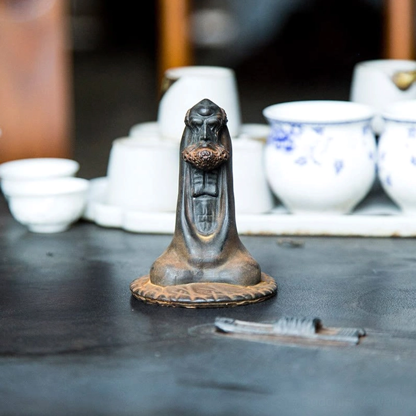 Bodhidharma meditation decor statue full body view on surface with spiritual ambiance
