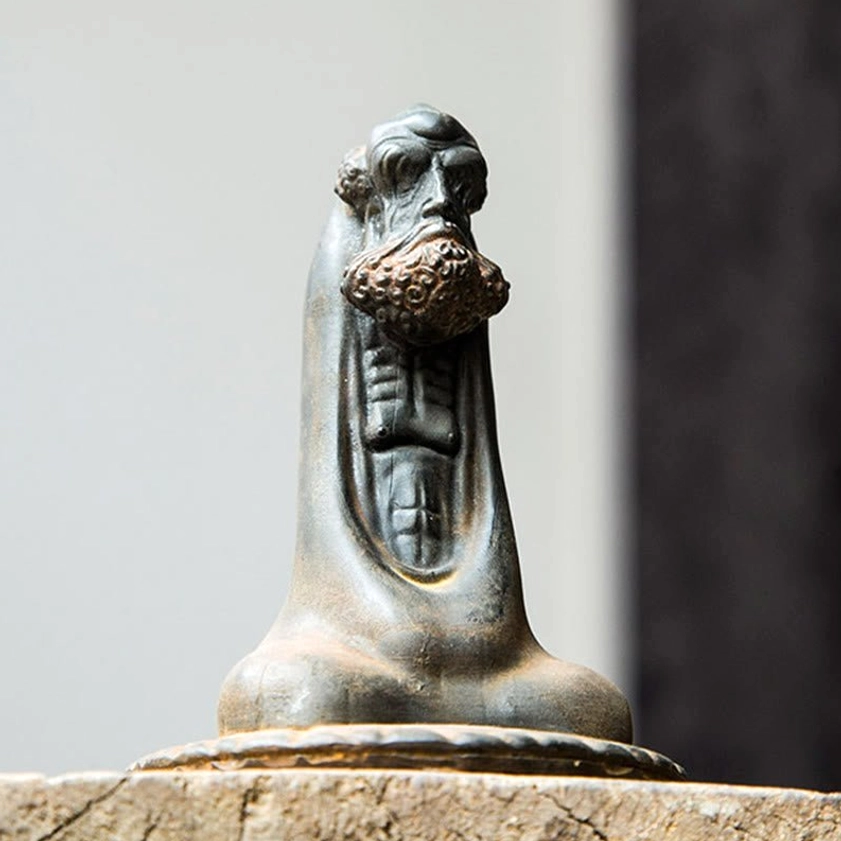 Bodhidharma iron resin statue low-angle front view with carved chest pattern and detailed beard
