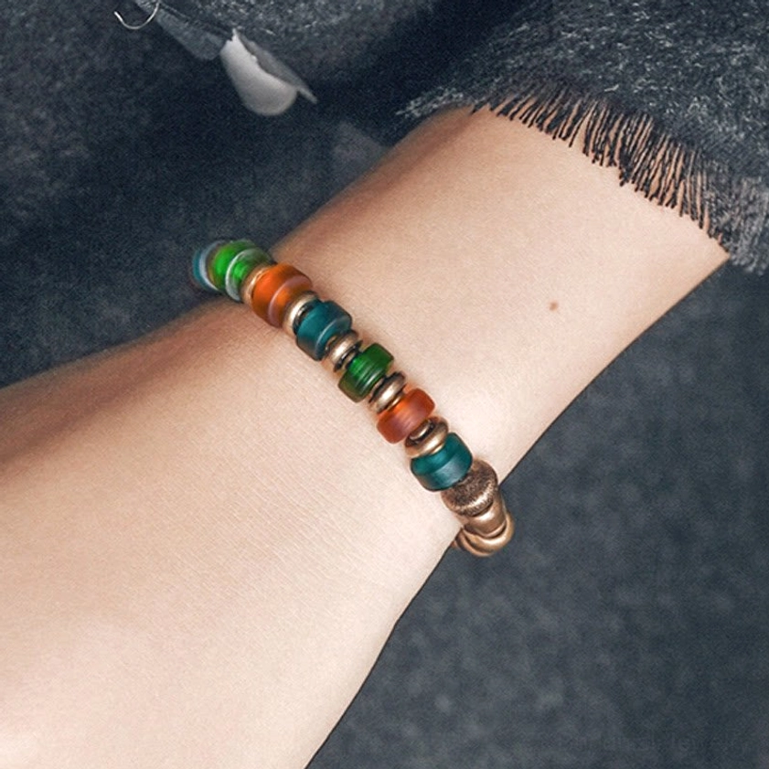 Bohemian colorful glass and copper bracelet featuring matte teal orange green beads with cylindrical copper accents