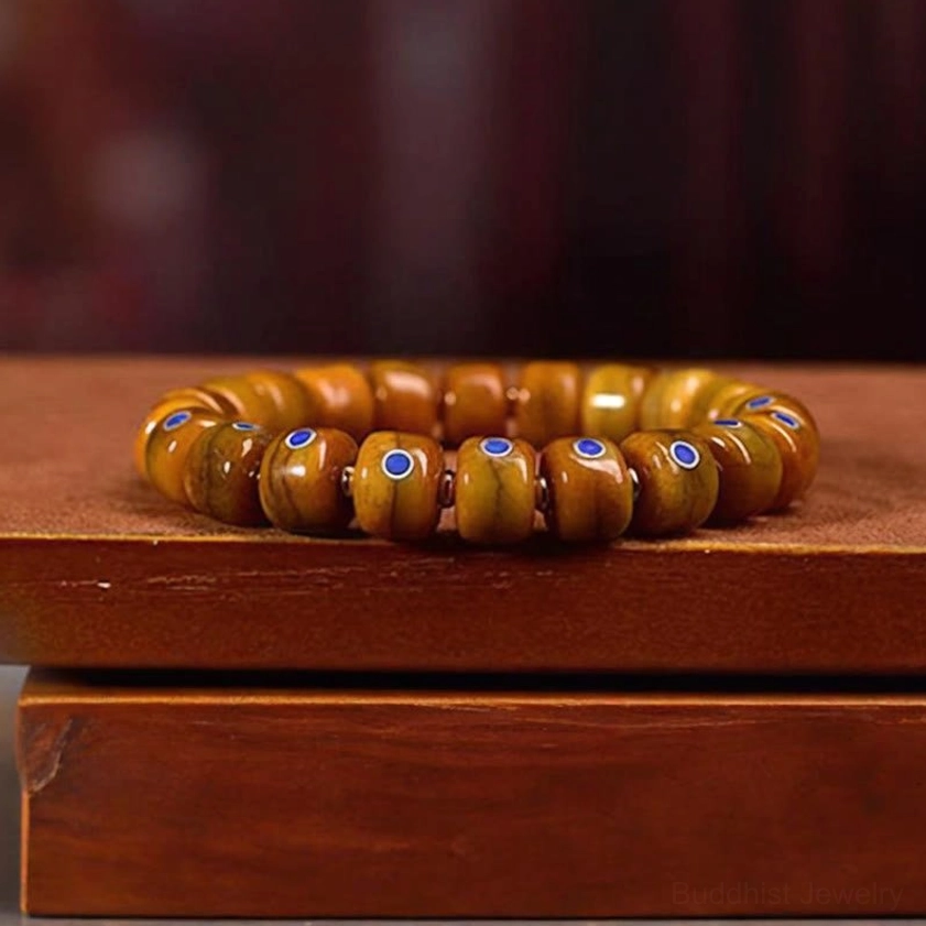 Buddhist bone bead bracelet side view on stacked wooden box showing bracelet profile