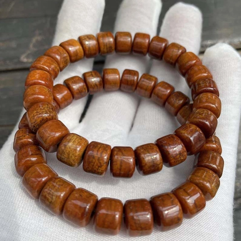 Two bone bead bracelets flat lay comparison with white gloves on wooden background