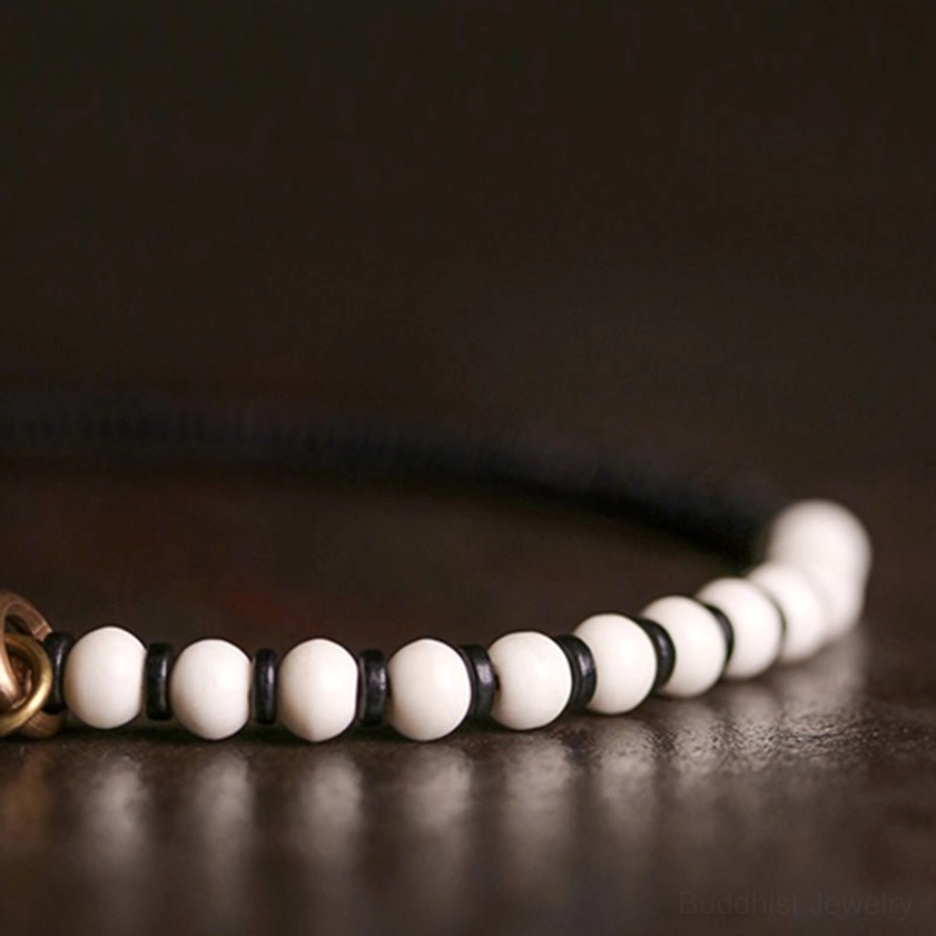 Macro close-up of bone beads and ebony wood string details with bronze spacer beads