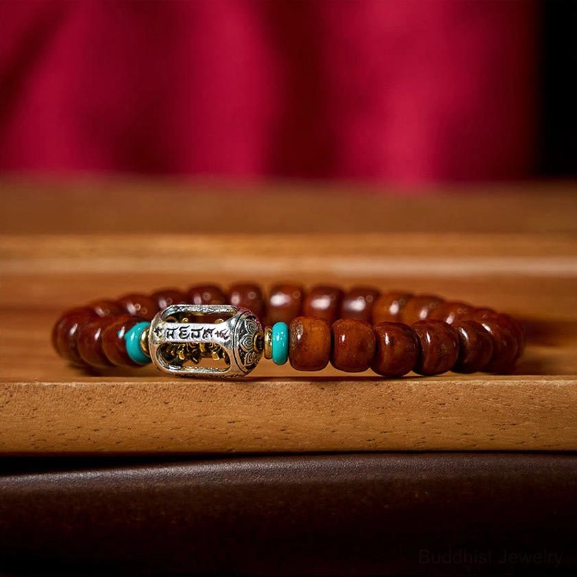 Bone bead and three-eye Dzi bracelet variant showing natural reddish-brown barrel beads with black-white Dzi bead centerpiece