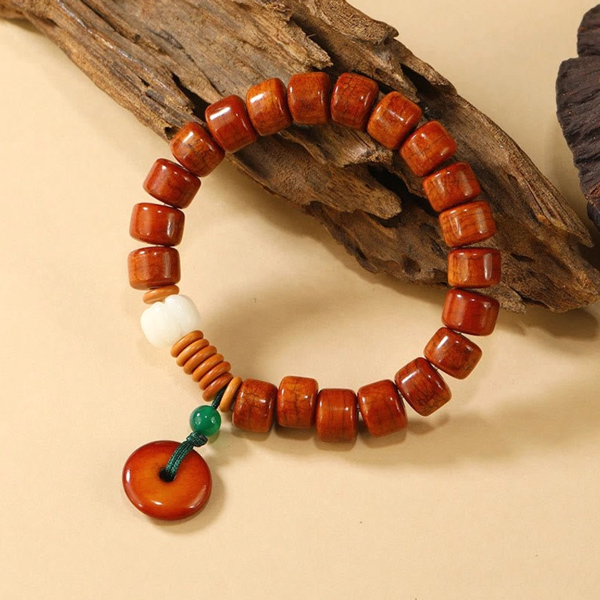 Buddhist prayer bracelet with bone barrel beads and red peace buckle charm angled view