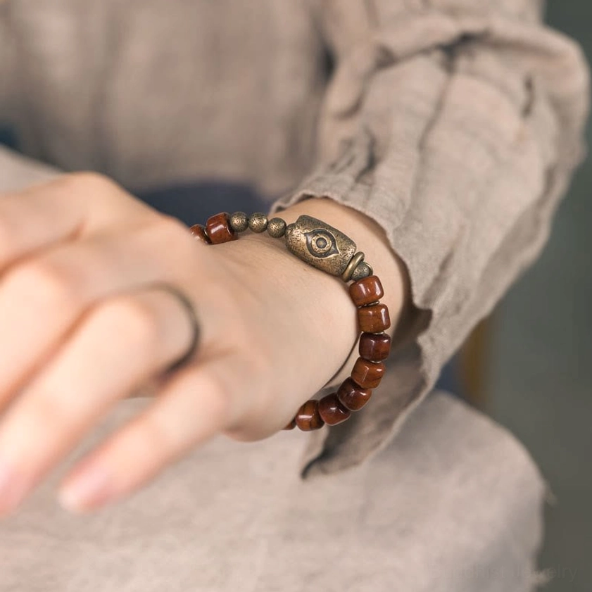 Hand-worn bone beads Buddhist bracelet on left wrist showing bohemian vintage design with metal ring and natural materials