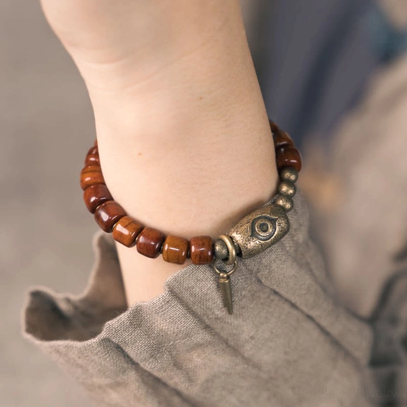 Bone beads Buddhist bracelet material details showing antique bronze Dzi charm copper cone pendant and natural bone texture